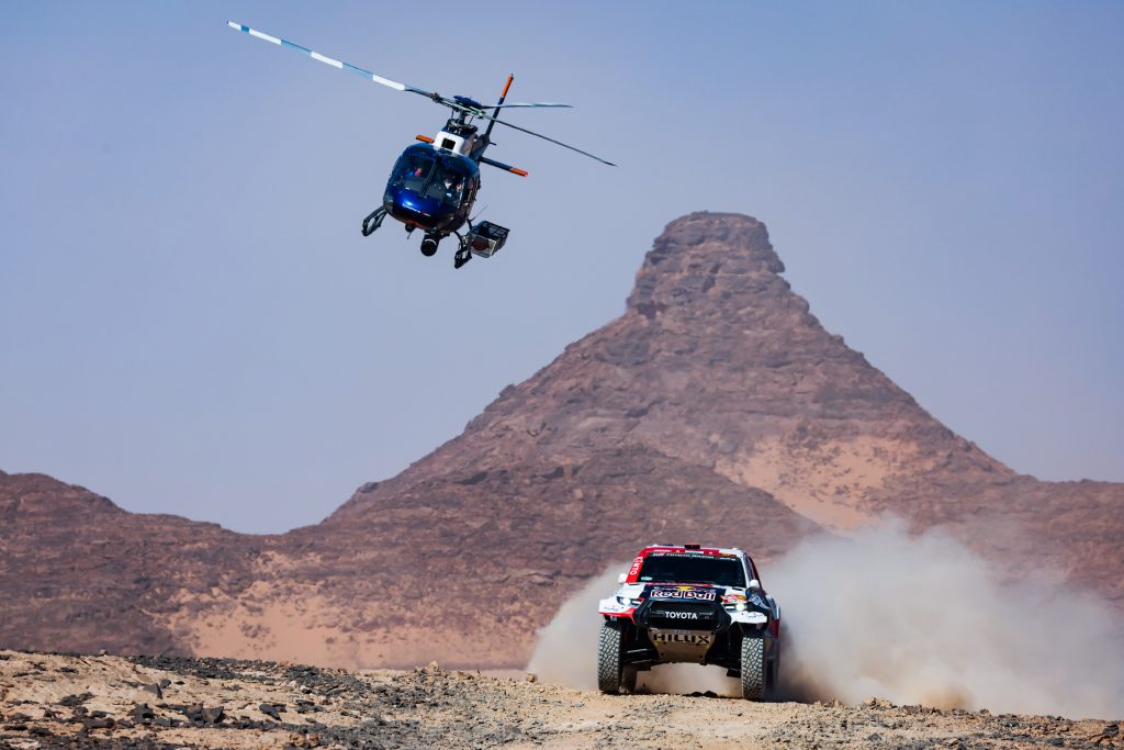 Nasser Al-Attiyah au Dakar 2022 et un hélicopter en fond
